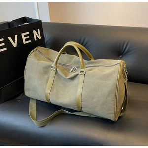 Detailed macro view of heavy canvas texture and leather handles on olive green travel bag