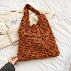 Detail view of caramel knit tote bag with 3D diamond weave pattern on white fabric