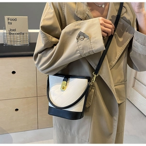 Chic quilted bucket bag in black and white leather styled with a khaki trench coat