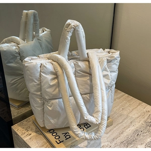 Dettaglio della borsa shopper trapuntata crema con motivi a quadri su pietra