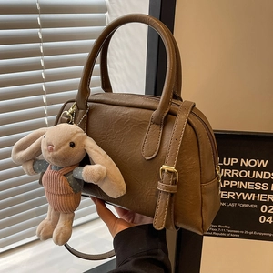 Vintage brown Boston bag for women with leather texture and cute rabbit charm detail