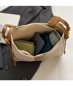 Bovenaanzicht van het ruime interieur van de beige leren tas met diverse persoonlijke spullen