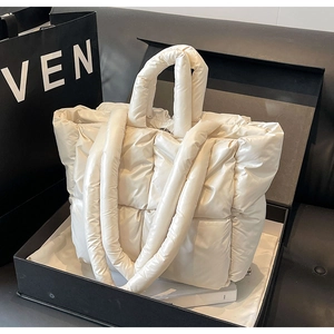 Dettaglio della borsa tote trapuntata bianco crema con finitura lucida e manici spessi