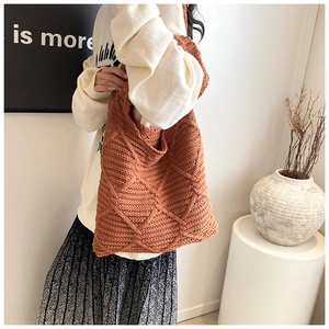 Borsa tote in maglia color caramello con motivo a rombi, mostrata in un ambiente chic