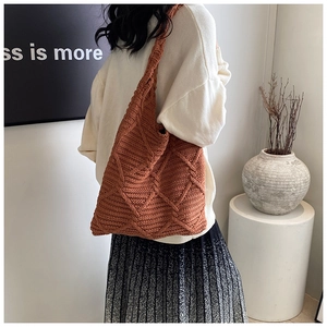 Dettaglio della borsa tote in maglia terracotta con motivo a trama di diamanti