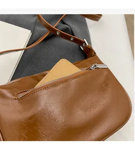 Close-up of the vintage brown leather shoulder bag featuring a functional rear zipper pocket