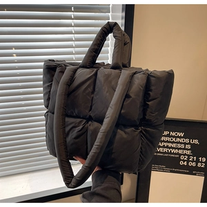 Dettaglio borsa tote trapuntata nera con manici imbottiti e tracolla per uso casual