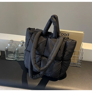 Dettaglio della borsa tote trapuntata nera in nylon imbottito con manico largo