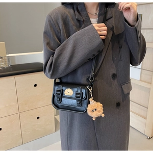Sac bandoulière rétro noir avec broderie chien et porte-clés en peluche sur un mannequin
