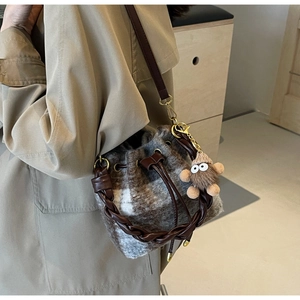 Détail du sac seau à carreaux en peluche avec poignée tressée et charm monstre