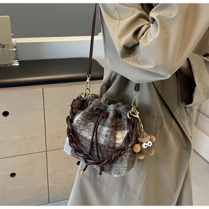 Détail du sac seau en laine à carreaux marron avec anse tressée et charm peluche