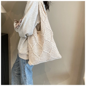 Dettaglio borsa tote in maglia beige con motivo a rombi e trama morbida della tracolla