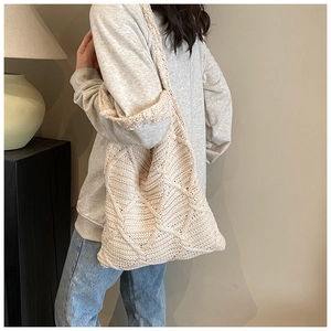 Dettaglio della borsa tote tessuta a mano con trama in maglia crema e grande tracolla