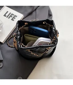Overhead view showing spacious interior of black quilted bucket bag with gold chain
