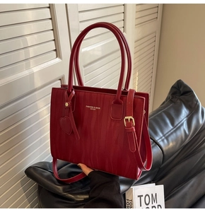 Détail du sac de mariée rouge avec motif animal texturé et finitions métalliques dorées