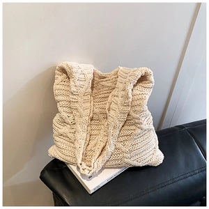 Dettaglio borsa tote in maglia panna con texture intrecciata e motivi a rombi definiti