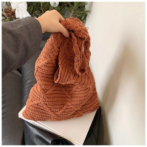 Dettaglio della borsa tote in maglia color caramello con trama a rombi e manico morbido