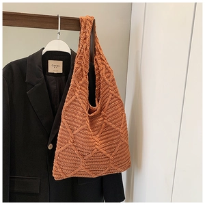 Primo piano della borsa tote in maglia terracotta con trama a rombi in rilievo 3D