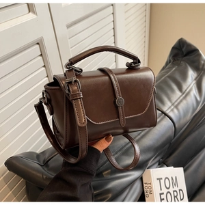 Detailed shot of dark brown vintage faux leather crossbody bag with metal buckle