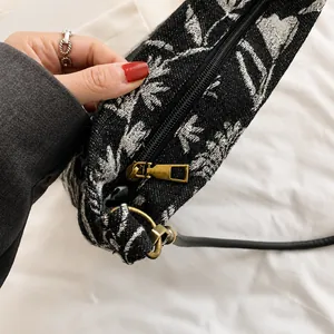 Detail of vintage bronze zipper and D-ring on black and white jacquard bucket bag