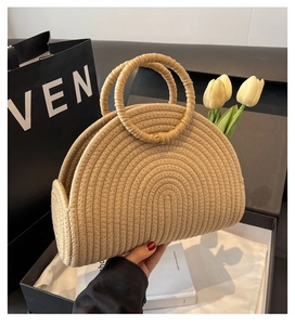 Detailed close-up of a semi-circular woven straw handbag with durable dual circular handles