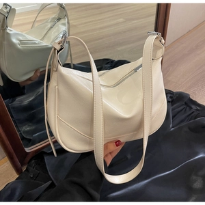 Detail view of cream vintage cracked leather texture on a crescent shoulder bag