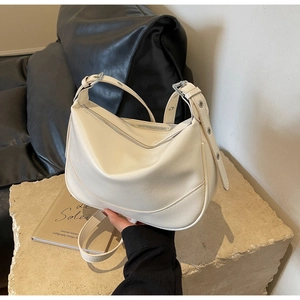 Close-up of cream hobo bag with adjustable strap and silver metal hardware details