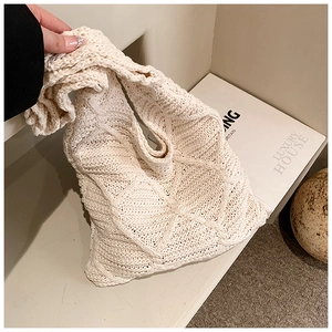 Dettaglio della borsa tote in maglia crema con motivo a rombi 3D e filato di cotone morbido