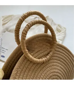 Detailed view of large straw beach bag featuring circular handles and spiral woven texture