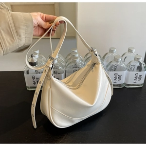 Detail of cream white crescent crossbody bag with adjustable wide eyelet shoulder strap