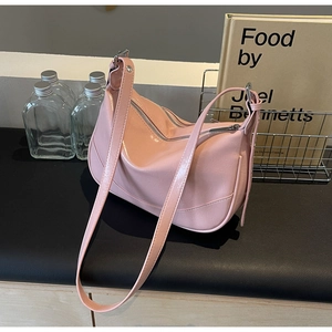 Detail of the pale pink hobo bag featuring smooth glossy texture and silver metal zippers