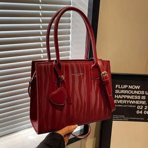 Sac à main élégant rouge foncé à texture ondulée avec poignée et breloque coeur
