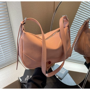 Detail of a pink glossy hobo bag with pleated texture and silver zipper closure