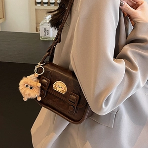Petit sac carré rétro marron foncé avec écusson animal et breloque peluche sur veste grise