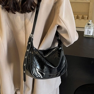 Glossy black pleated leather half-moon shoulder bag with adjustable eyelet strap