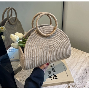 Detailed view of beige woven tote bag with circular handles and tulip flowers