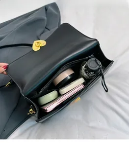 Vue détaillée de l'intérieur du sac en cuir noir avec serrure coeur et poche zippée