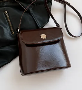 Detail van bordeauxrode lederen handtas met vintage zilverkleurige metalen hardware