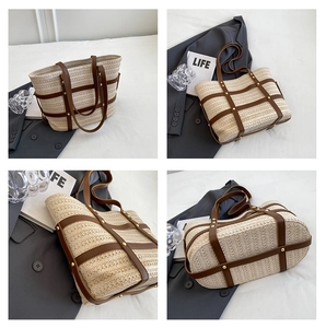 Detailed view of straw tote bag with brown leather handles and golden rivets reinforcement