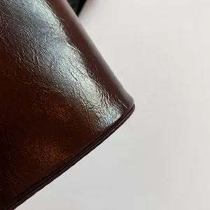Detail van glanzend geplooid lakleer voor een bruidstasje met gladde lederen textuur