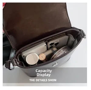 Detailweergave van de grote capaciteit en vakken van de glanzende leren handtas voor dames