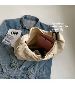 Nylon crescent bag showing large capacity with internal space for tablet and notepad
