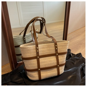Detailed macro view of woven tote bag with brown leather straps and metallic rivets