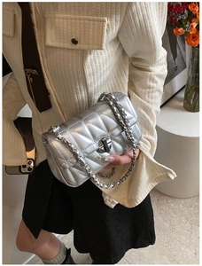 Detailsicht einer silbernen Stepptasche mit Metallic-Finish und Drehverschluss-Kette