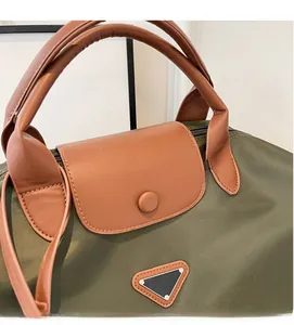 Détail du nylon vert armée avec poignées en cuir marron et plaque métallique triangulaire