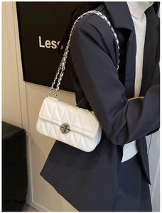 Detailansicht der weißen Stepptasche mit Silberverschluss und Kettenriemen