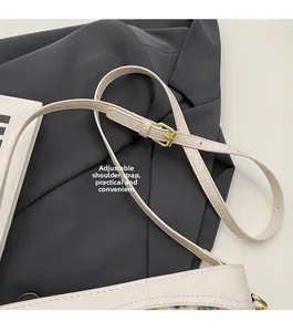 Close-up of adjustable leather shoulder strap with golden metal buckle on beige bucket bag