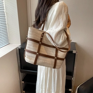 Minimalist beige woven tote bag with brown leather straps and metal rivets for women