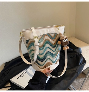 Close-up of knit wave texture and faux leather trim on a designer bucket bag