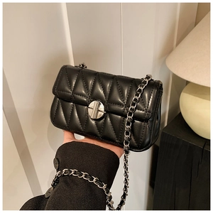Detailaufnahme der schwarzen Stepptasche mit silbernem Drehverschluss und Kettenriemen